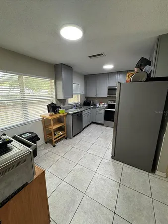 a kitchen with stainless steel appliances a refrigerator a sink a stove top oven a counter space and cabinets