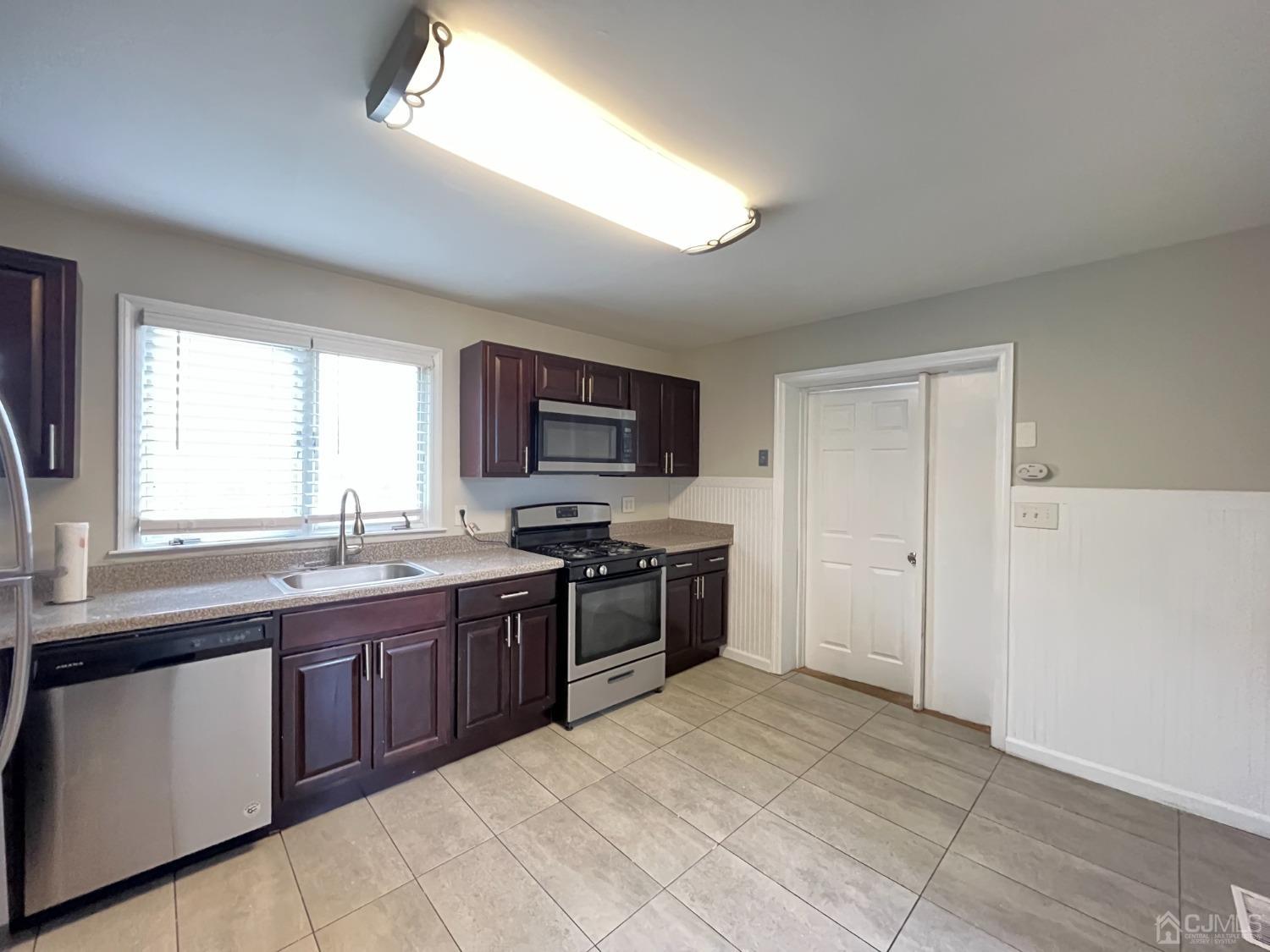 37 Thomas Street Perth Amboy, NJ 08861 - Photo 2 of 30 a large kitchen with cabinets appliances and a window