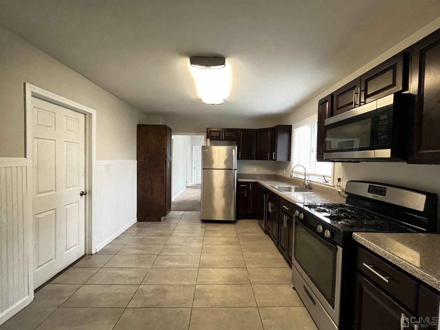 37 Thomas Street Perth Amboy, NJ 08861 - Photo 3 of 30 a kitchen with stainless steel appliances granite countertop a stove top oven a sink dishwasher a refrigerator and a microwave