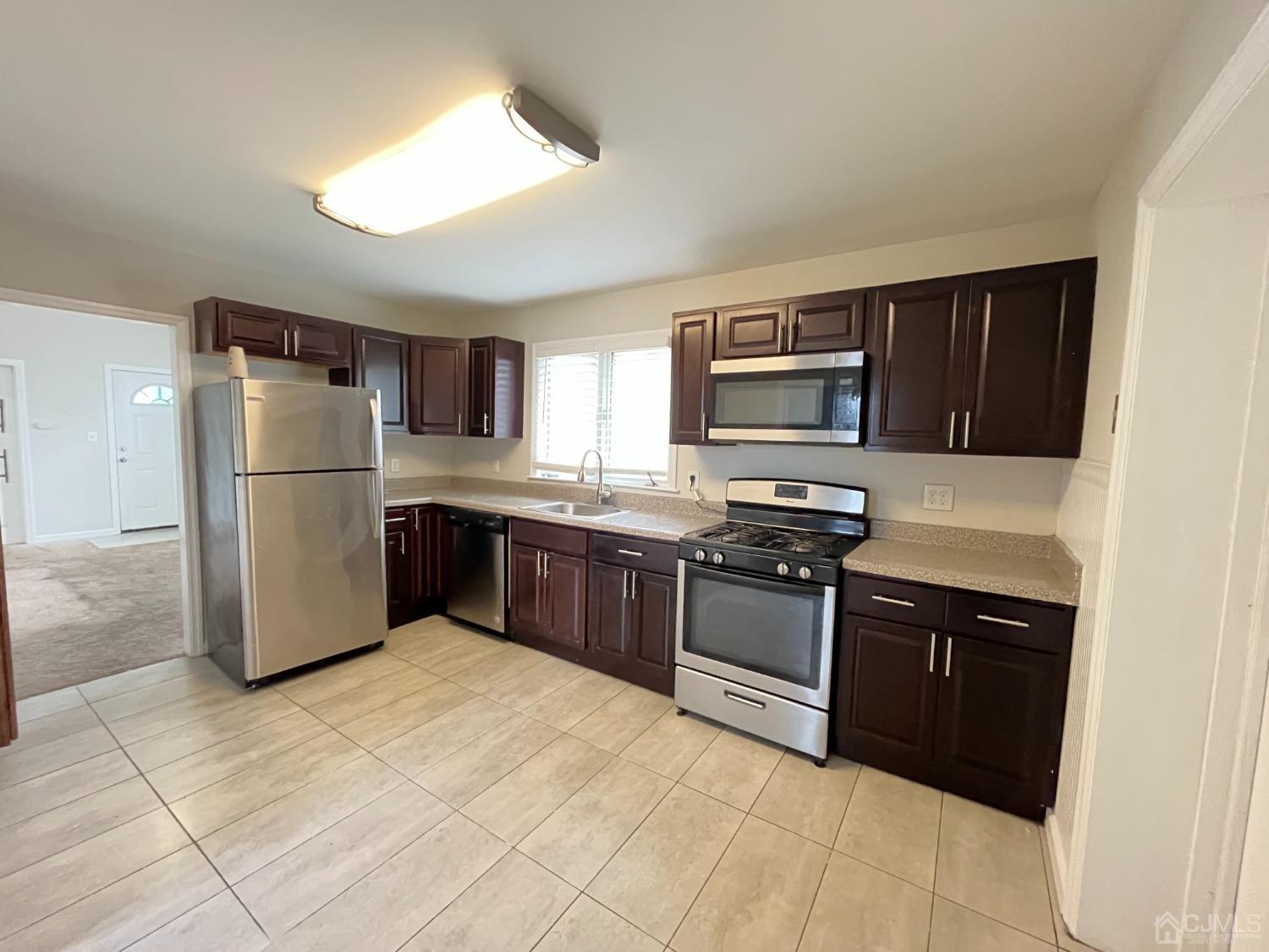 37 Thomas Street Perth Amboy, NJ 08861 - Photo 4 of 30 a kitchen with a refrigerator sink and wooden cabinets