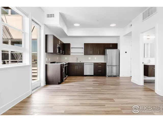 a view of living room kitchen with stainless steel appliances kitchen island