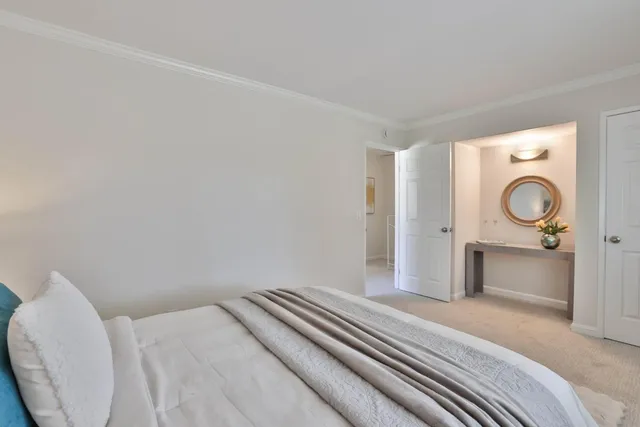 a bedroom with a bed and a lamp on dresser