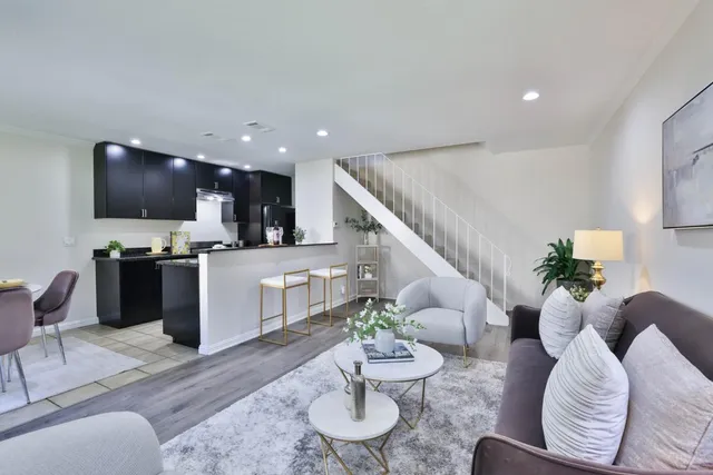 a living room with furniture kitchen view and a flat screen tv
