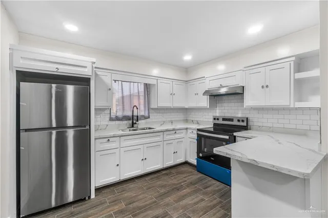 a kitchen with white cabinets stainless steel appliances and sink