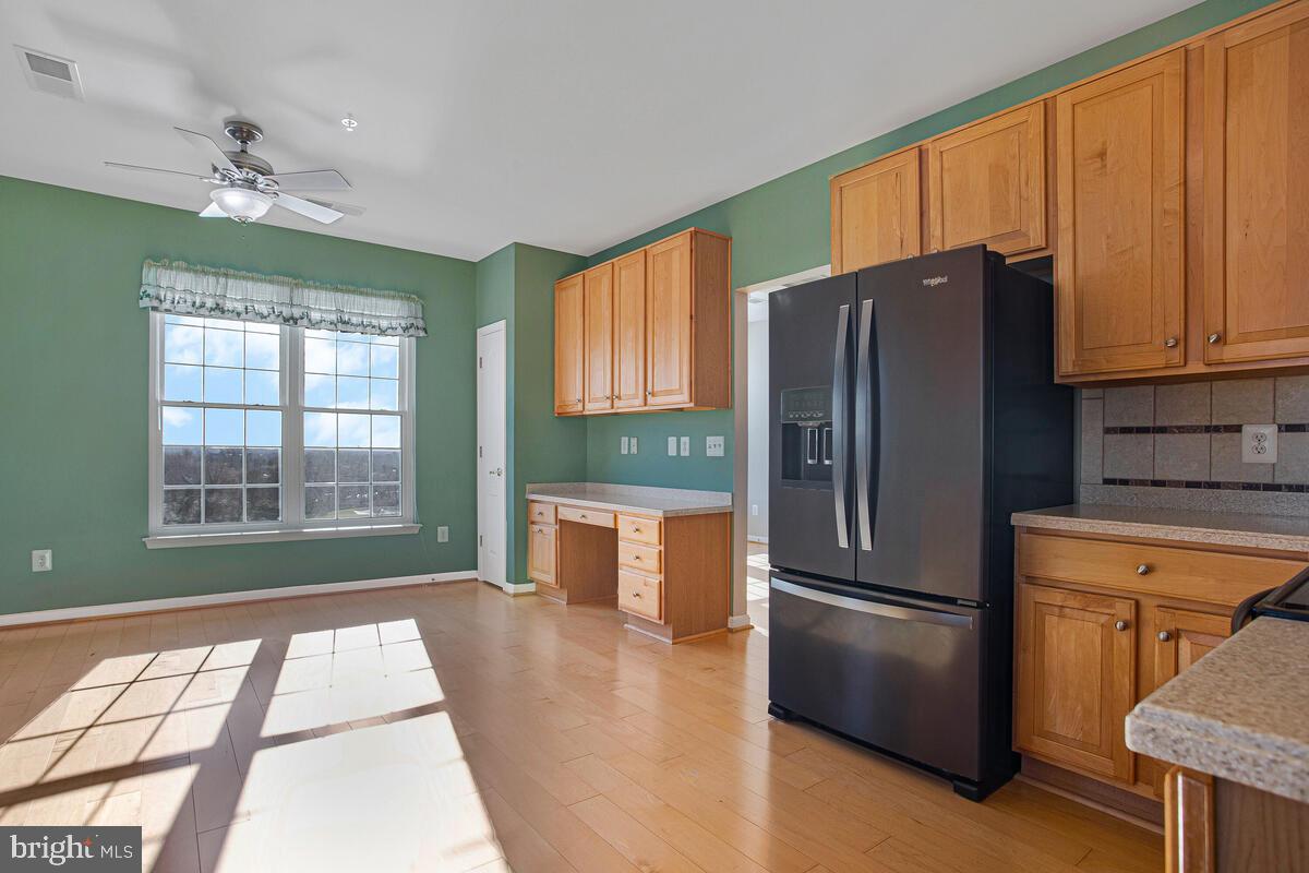 7325 Brookview Road, Unit 403 Elkridge, MD 21075 - Photo 18 of 65 a kitchen with stainless steel appliances granite countertop a refrigerator a stove and a window with wooden floors