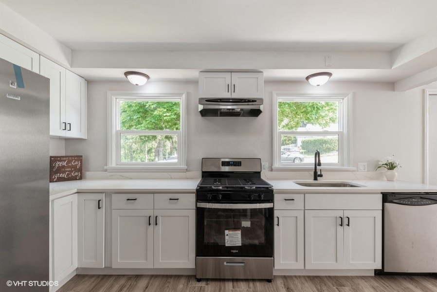 403 Highview Drive Fox River Grove, IL 60021 - Photo 4 of 18 a kitchen with white cabinets and a stove top oven