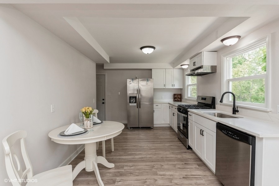 403 Highview Drive Fox River Grove, IL 60021 - Photo 5 of 18 a kitchen with stainless steel appliances a dining table chairs and window
