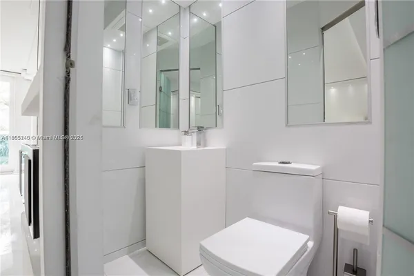 a bathroom with a toilet a sink and mirror