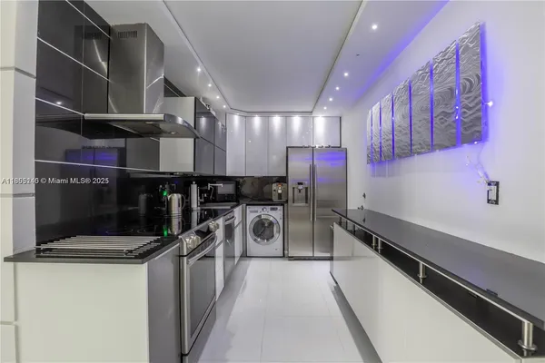a kitchen with stainless steel appliances a stove a sink and a refrigerator