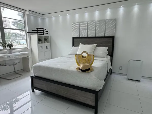 a bedroom with a bed and a large mirror