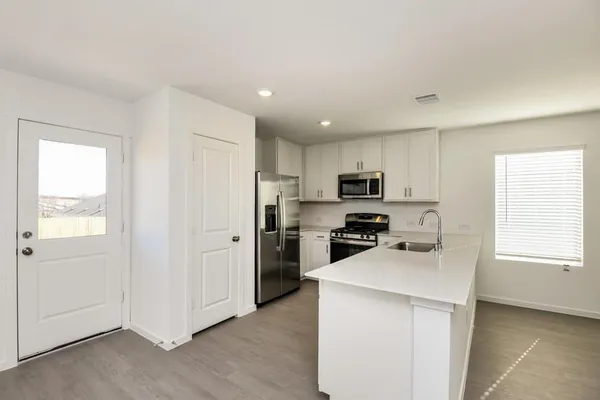 a kitchen with cabinets stainless steel appliances a sink and a window