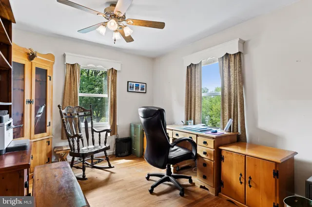 a view of a workspace with furniture and a window