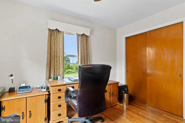 a view of workspace with wooden floor and a window
