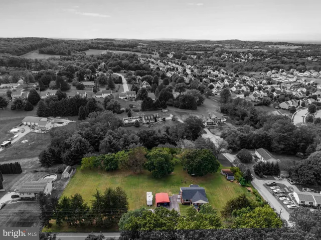 an aerial view of residential houses with outdoor space and trees