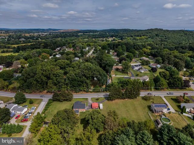 an aerial view of residential houses with outdoor space and trees