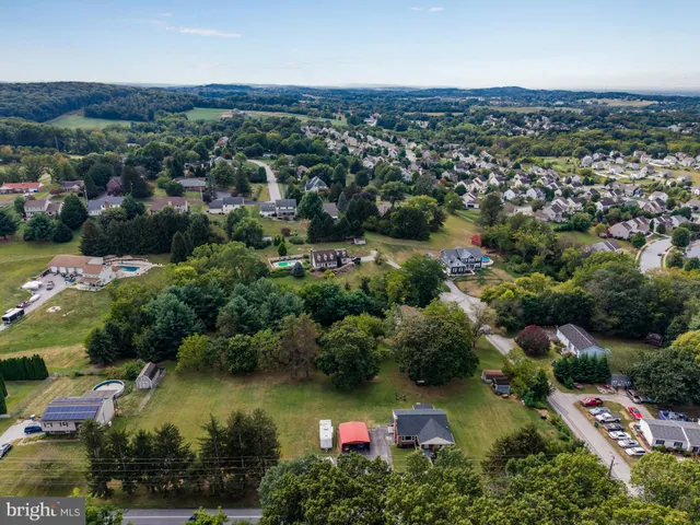 an aerial view of residential houses with outdoor space and lake view