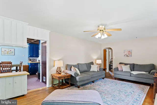 a living room with furniture and a dining table with wooden floor