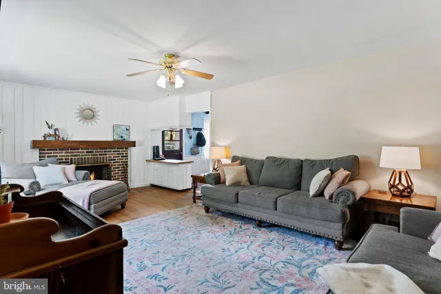 a living room with furniture a fireplace and a chandelier