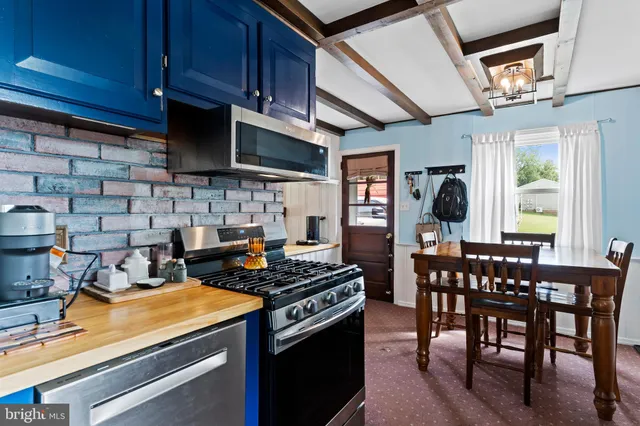 a kitchen with stainless steel appliances granite countertop a stove a sink dishwasher and cabinets with wooden floor
