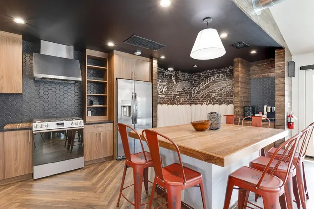 a kitchen with stainless steel appliances granite countertop a stove a sink and a refrigerator