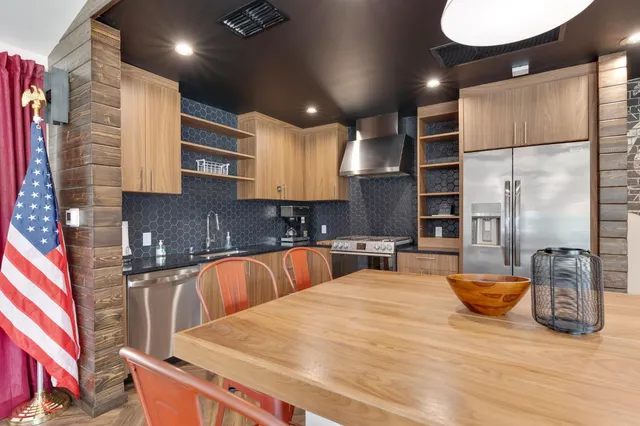 a kitchen with stainless steel appliances kitchen island granite countertop a sink and cabinets