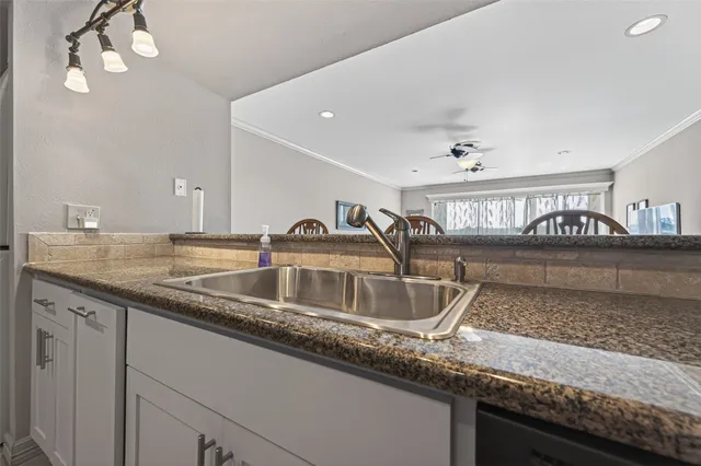 a kitchen with granite countertop a stove top oven microwave and cabinets