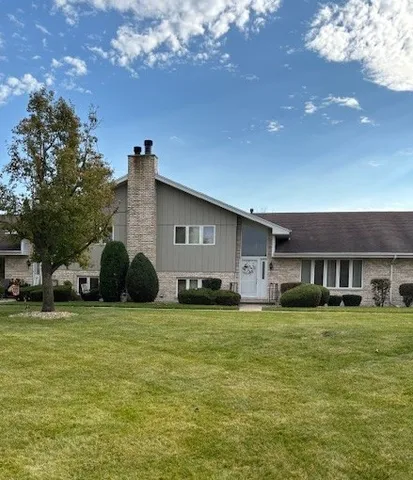 a view of a house with a big yard and large trees