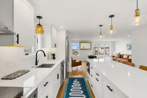 a kitchen with stainless steel appliances a stove a sink and a refrigerator