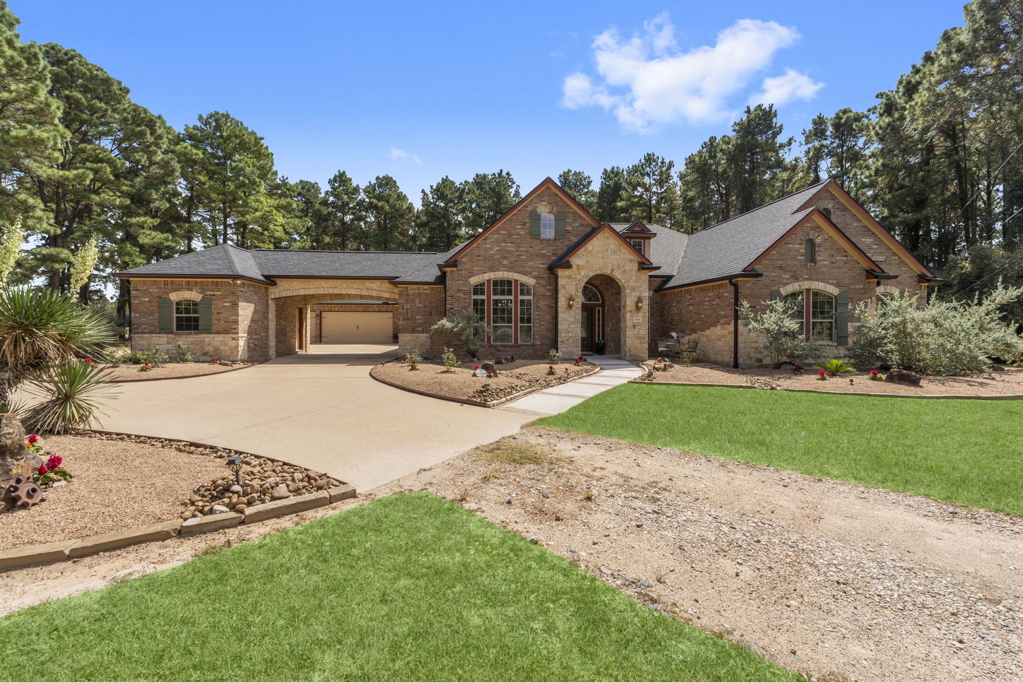 1534 Virgie Community Road Magnolia, TX 77354 - Photo 5 of 50 A stunning country estate home set among tall trees and greenery, with a long driveway leading up to a warm, inviting front entrance. The timeless charm and welcoming presence makes a grand first impression.