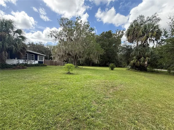 a swimming pool is sitting in a big yard with large trees