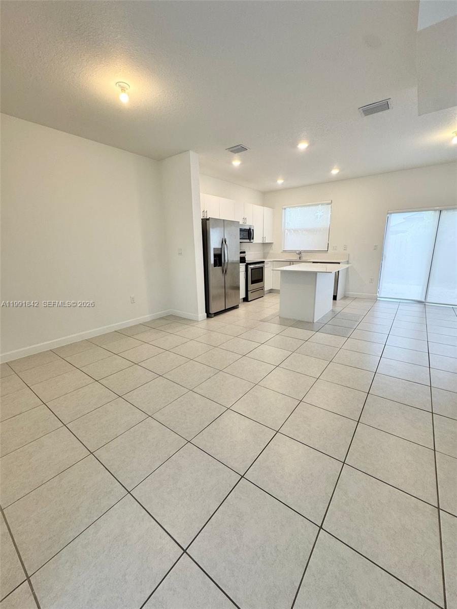 12986 Southwest 232nd Terrace, Unit 12986 Homestead, FL 33032 - Photo 2 of 11 a view of a kitchen with furniture and natural light