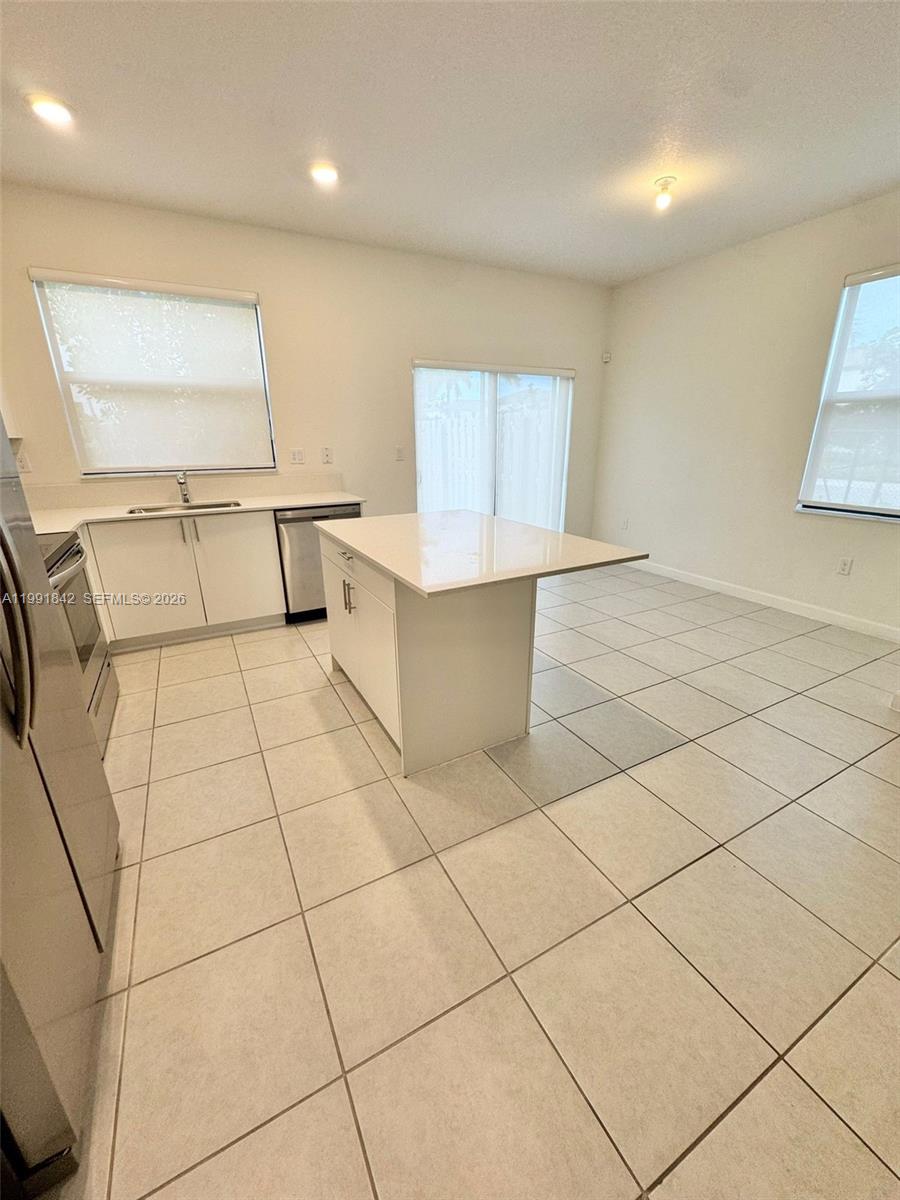 12986 Southwest 232nd Terrace, Unit 12986 Homestead, FL 33032 - Photo 3 of 11 a view of a kitchen with furniture and wooden floor