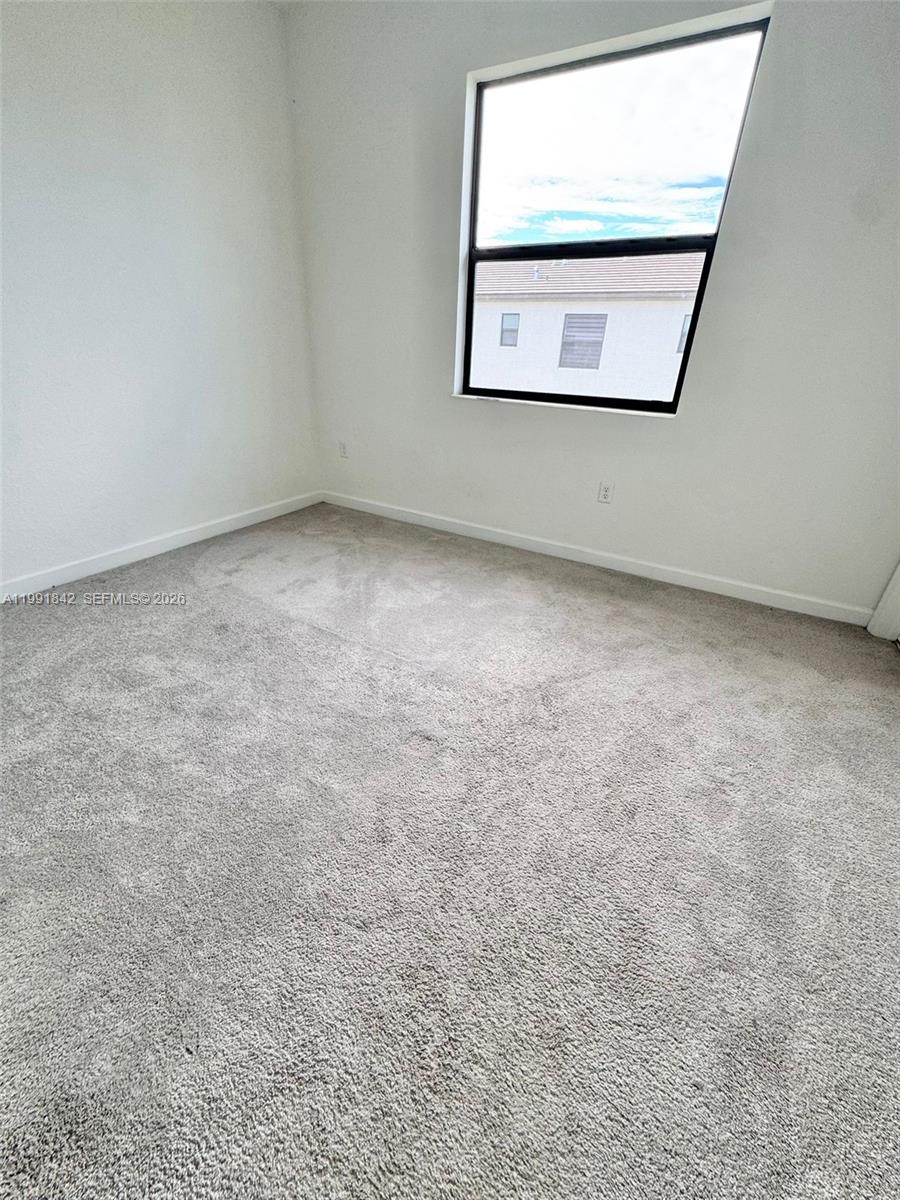 12986 Southwest 232nd Terrace, Unit 12986 Homestead, FL 33032 - Photo 5 of 11 an empty room with a window