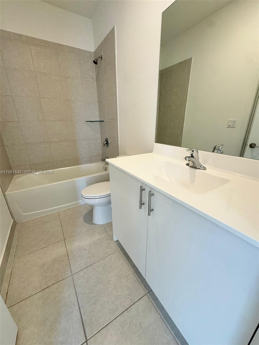 12986 Southwest 232nd Terrace, Unit 12986 Homestead, FL 33032 - Photo 6 of 11 a bathroom with a bathtub shower sink vanity and toilet