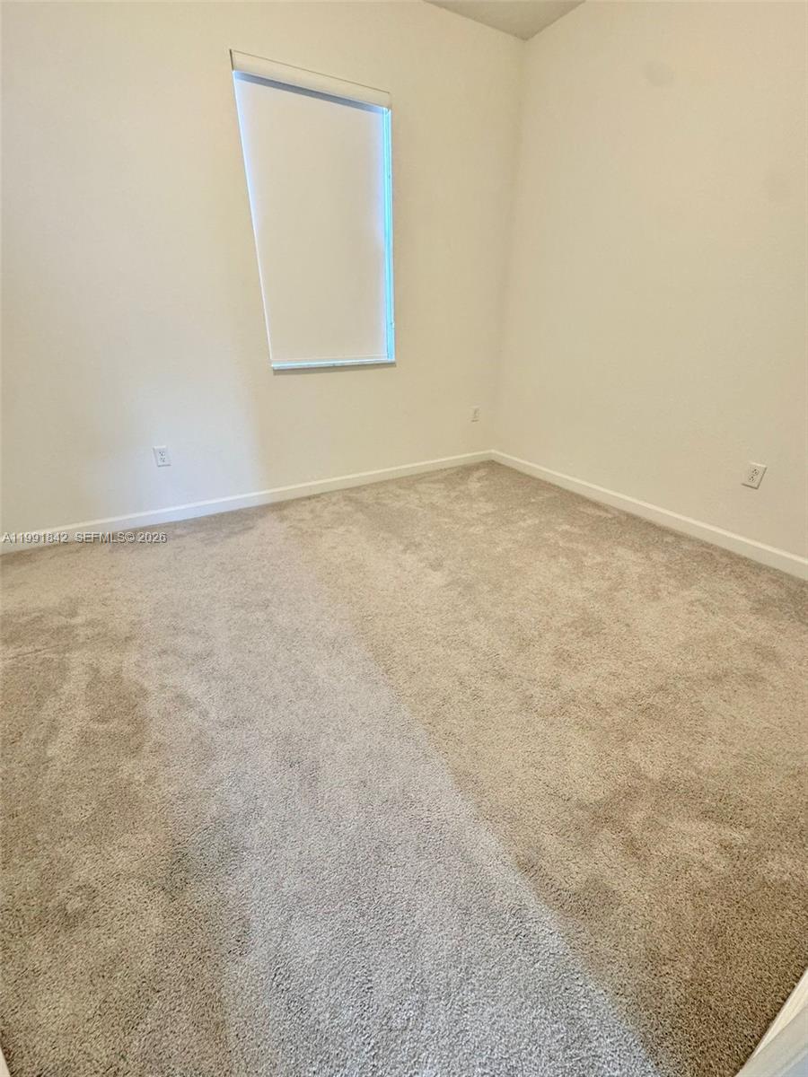 12986 Southwest 232nd Terrace, Unit 12986 Homestead, FL 33032 - Photo 7 of 11 an empty room with a window