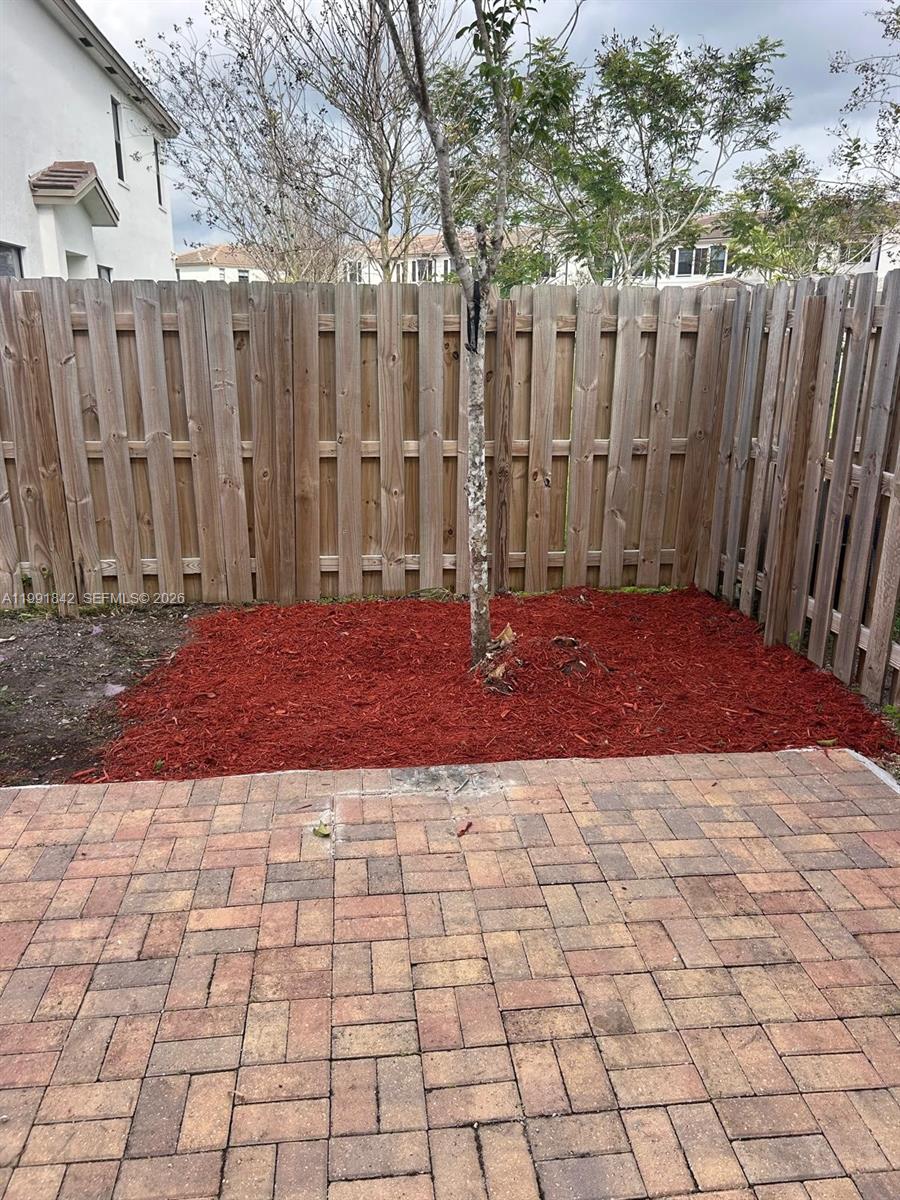 12986 Southwest 232nd Terrace, Unit 12986 Homestead, FL 33032 - Photo 9 of 11 a view of a backyard with white fence