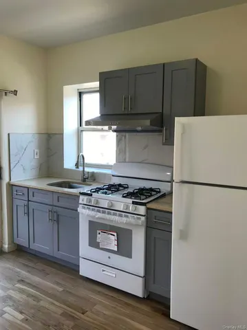 a kitchen with granite countertop a stove and a refrigerator