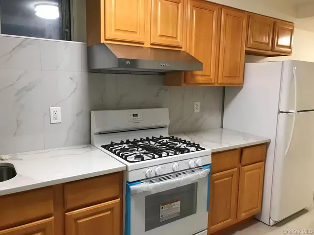 a kitchen with granite countertop a sink stove and refrigerator