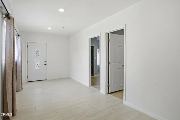 a view of a kitchen with refrigerator and wooden floor