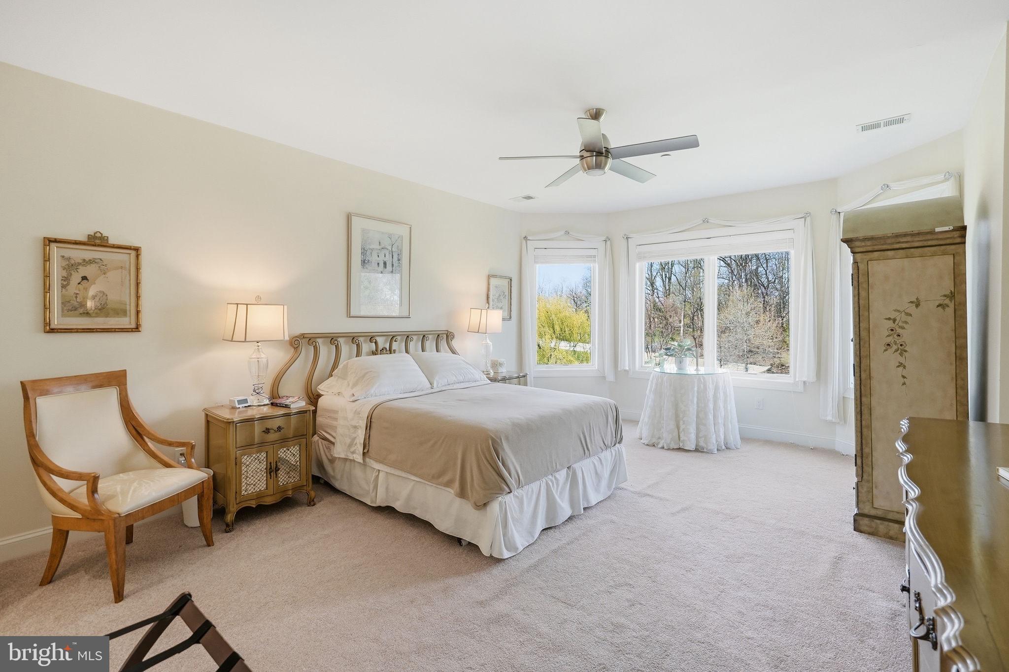 10708 Lockland Road Potomac, MD 20854 - Photo 40 of 69 a spacious bedroom with a bed a table and painting