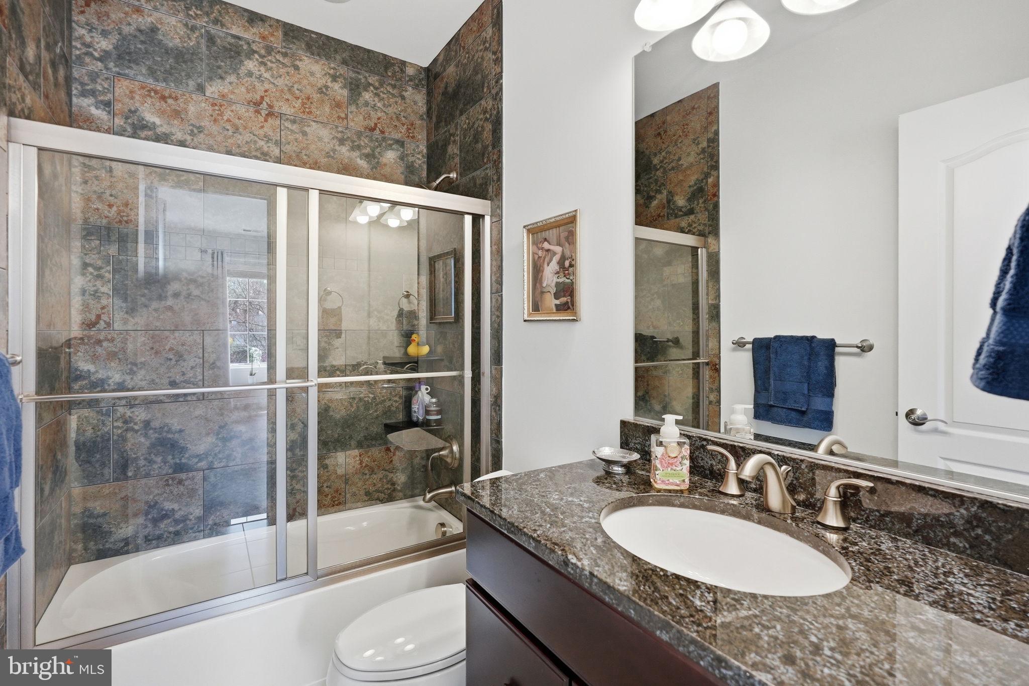 10708 Lockland Road Potomac, MD 20854 - Photo 45 of 69 a bathroom with a granite countertop sink toilet and shower