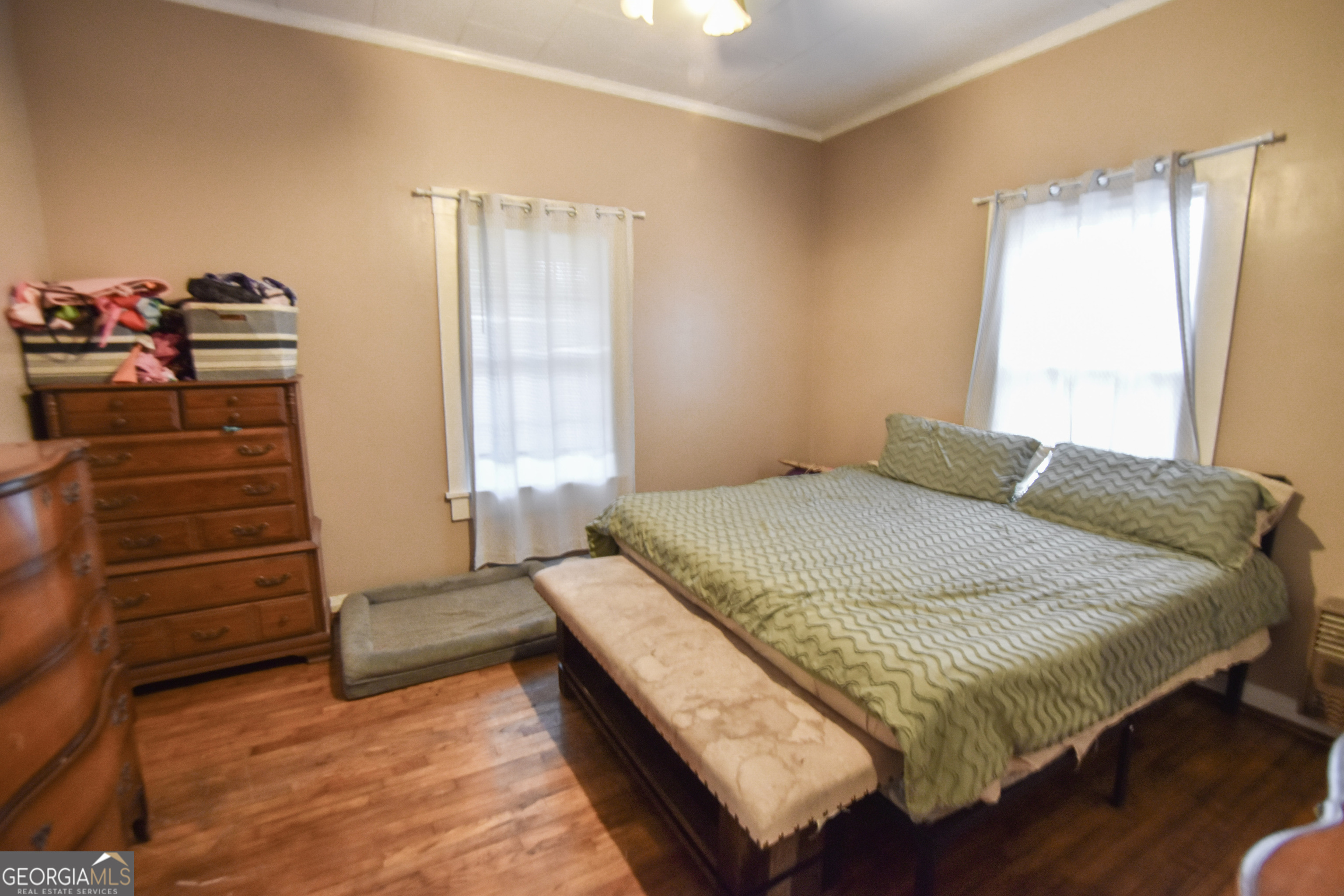 908 East McCarty Street Sandersville, GA 31082 - Photo 11 of 20 a bedroom with a bed and wooden floor