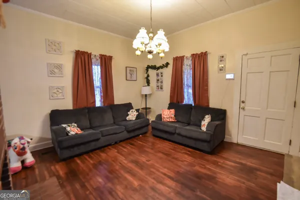 a living room with furniture and a chandelier