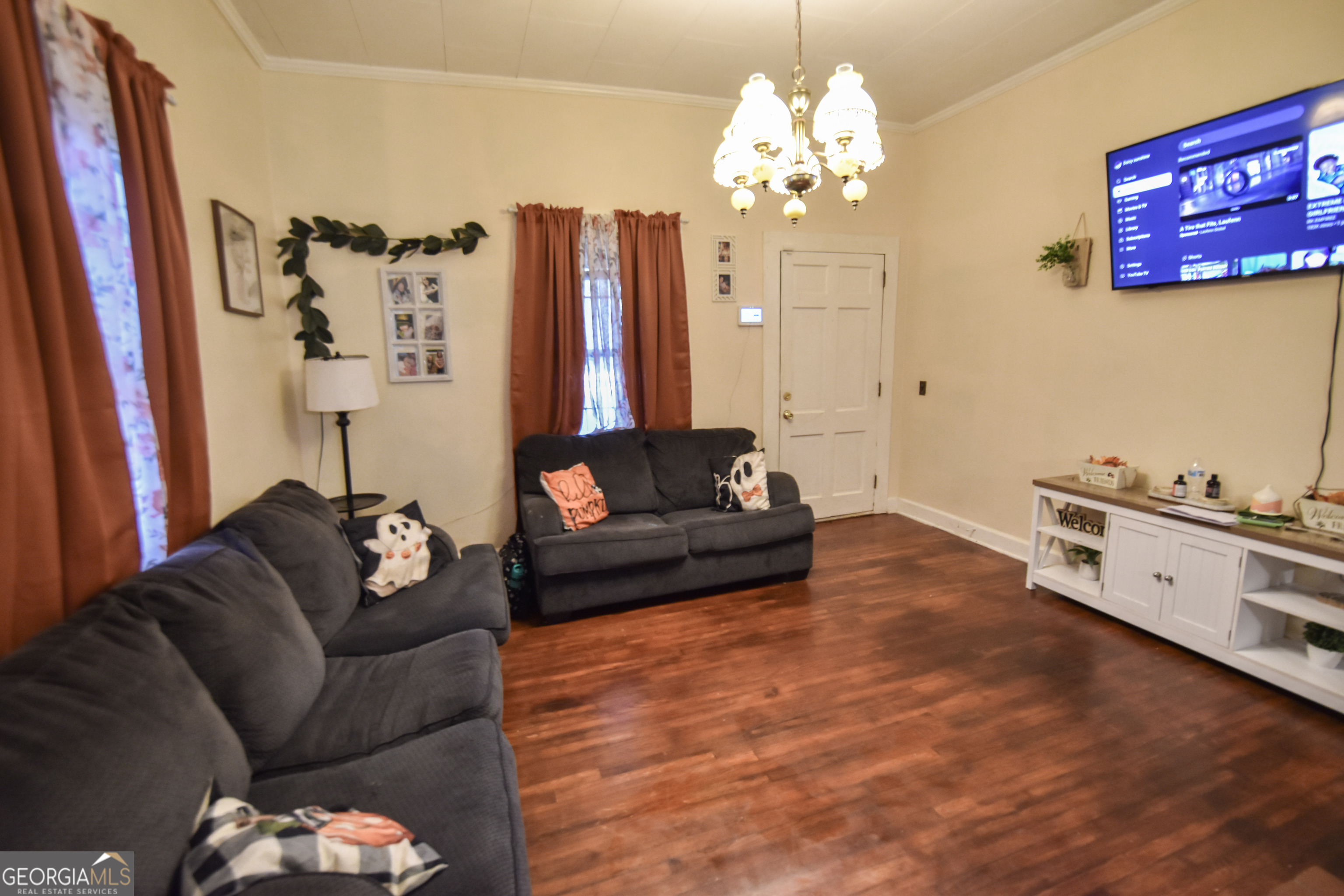908 East McCarty Street Sandersville, GA 31082 - Photo 4 of 20 a living room with furniture and a chandelier