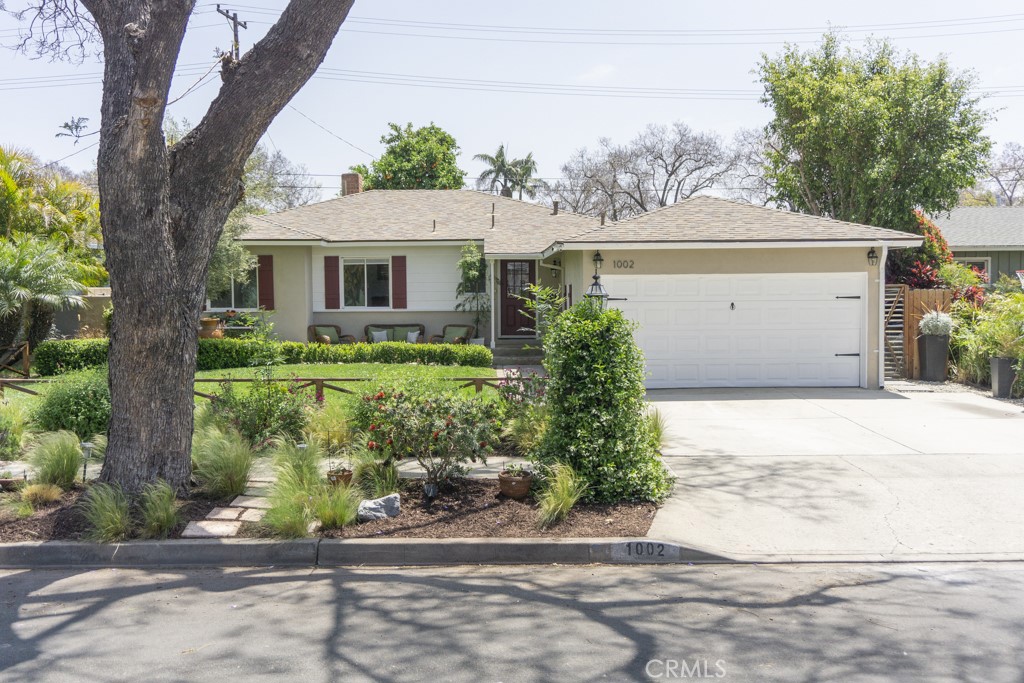 a front view of a house with a yard and potted plants