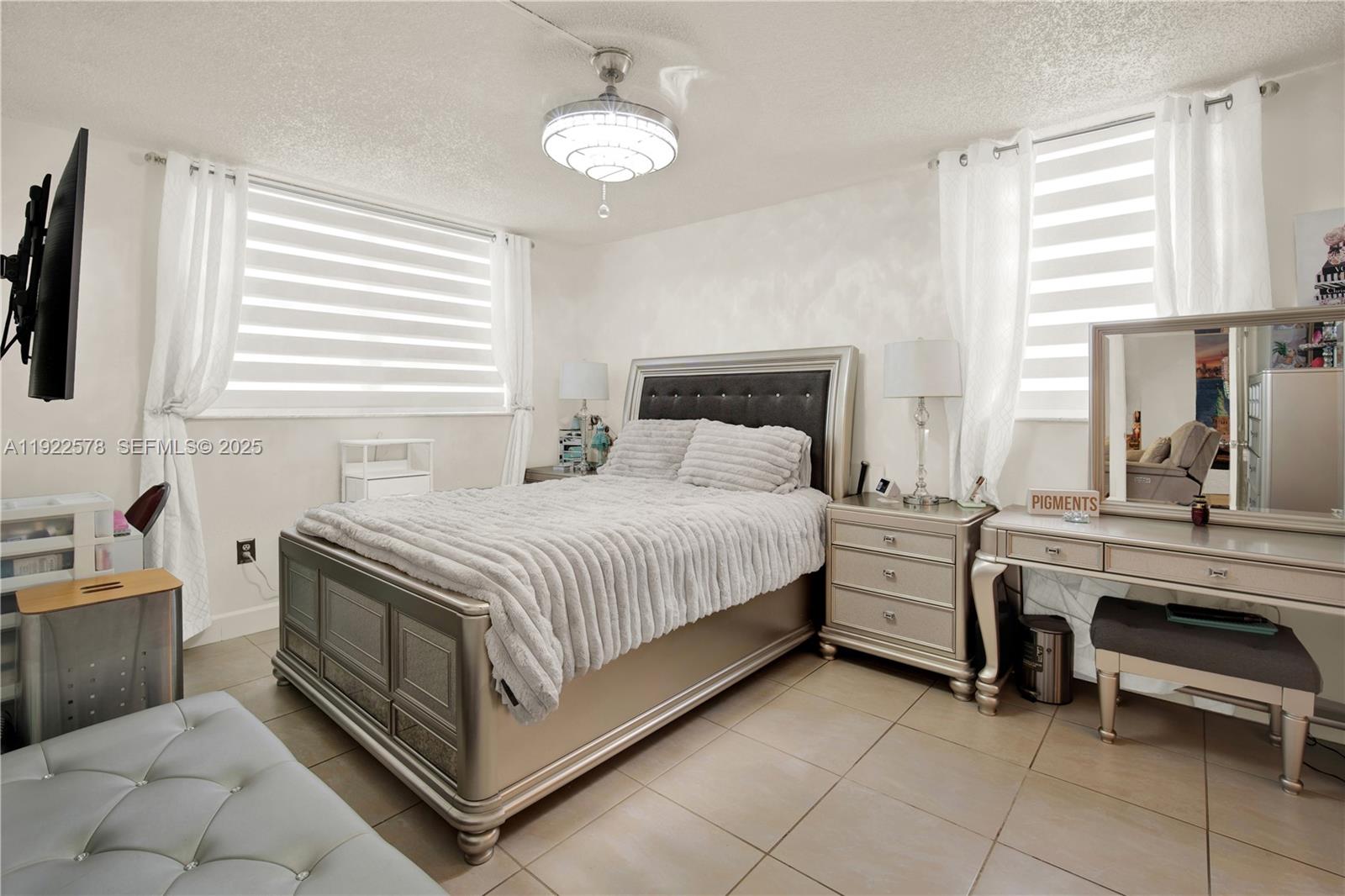 14195 Southwest 87th Street, Unit B115 Miami, FL 33183 - Photo 16 of 22 a bedroom with a bed and a chandelier