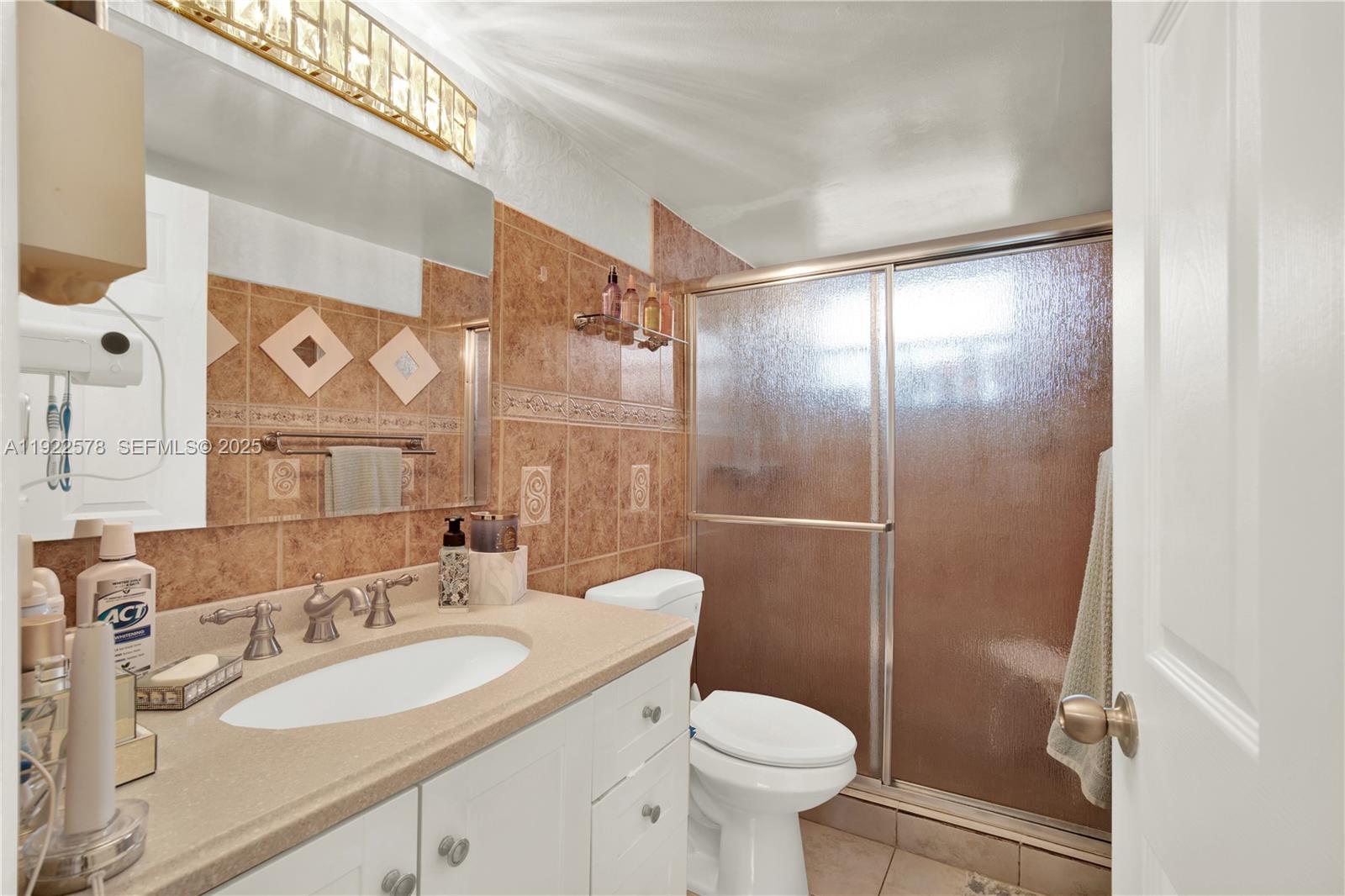 14195 Southwest 87th Street, Unit B115 Miami, FL 33183 - Photo 17 of 22 a bathroom with a sink a toilet and shower