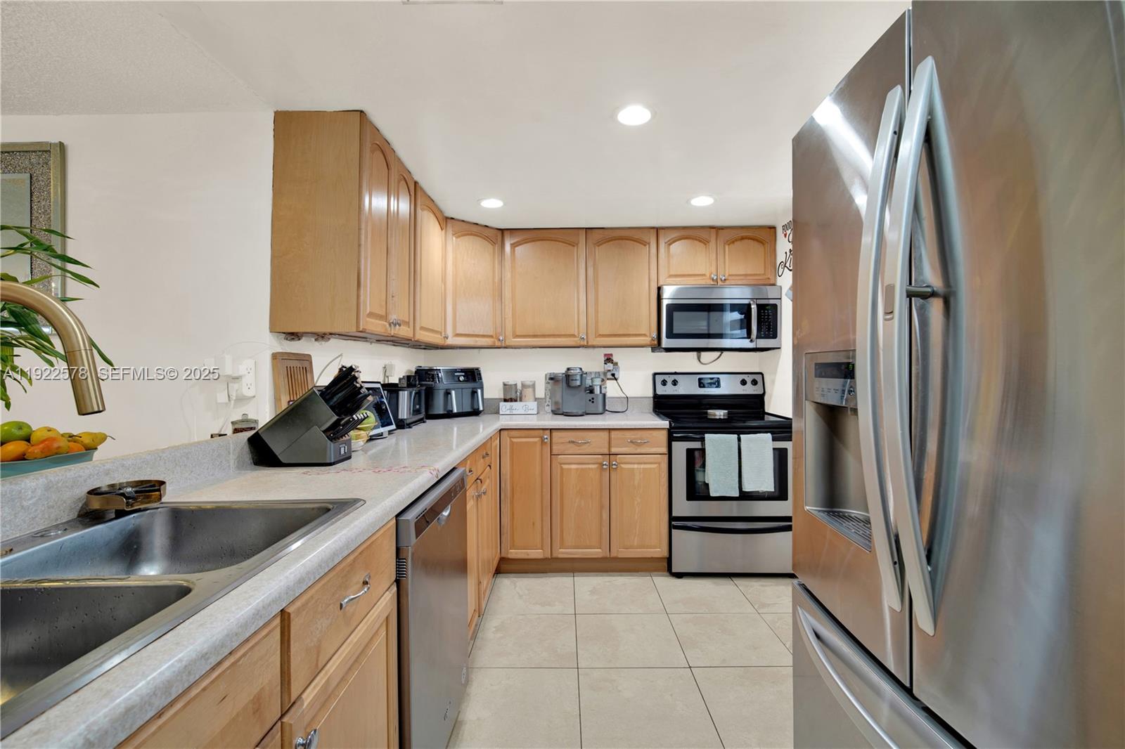 14195 Southwest 87th Street, Unit B115 Miami, FL 33183 - Photo 8 of 22 a kitchen with granite countertop stainless steel appliances and sink