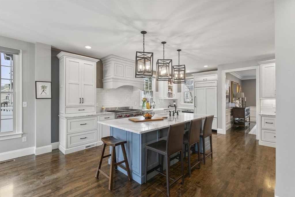 27 Sherman Street Lexington, MA 02420 - Photo 6 of 30 a kitchen with stainless steel appliances a dining table chairs and wooden floor