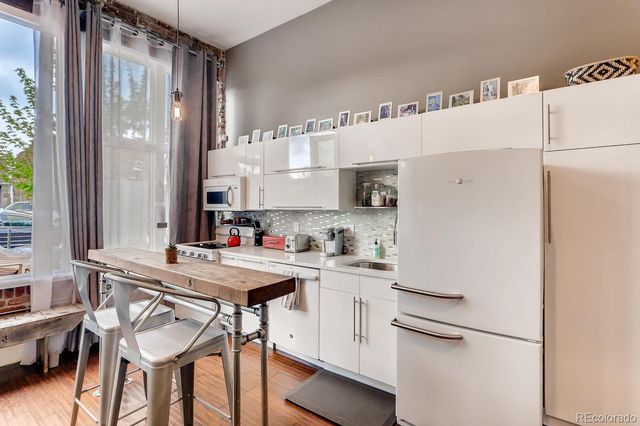 a kitchen with a white refrigerator and cabinets